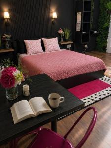 a bedroom with a bed and a table with a book at Studio Superstar in Forbach
