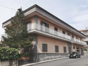 a car parked in front of a building with a balcony at New Magnolia House in Belpasso