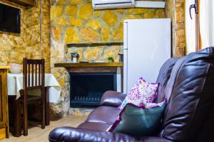 a leather couch in a living room with a fireplace at Apartamento Corralazos in Castril