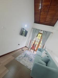 a living room with a blue couch and a window at Lanthana Villa Kandy in Kandy