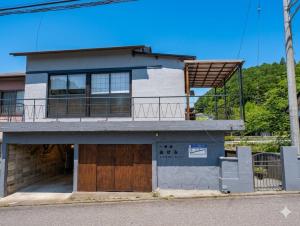 a house with a balcony on top of it at 川まで徒歩1分川沿いにある一軒宿あせみ in Nakajima