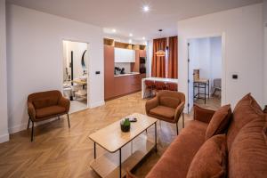 a living room with a couch and chairs and a table at OIKOS APARTAMENTOS TURÍSTICOS in Monesterio