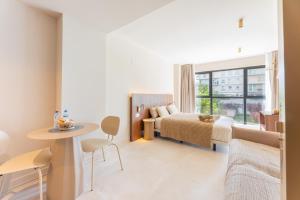 a bedroom with a bed and a table and a window at A2B Collection Arena in Valencia