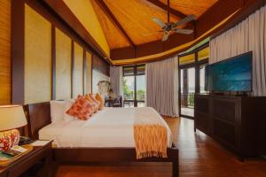 a bedroom with a bed and a flat screen tv at Lihim Resorts in El Nido +217 photos