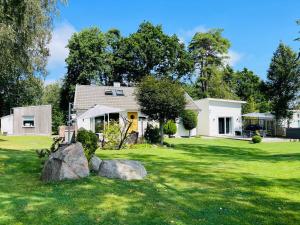 a house with a yard with rocks in the grass at 2 Modern guesthouses near The Beach in Falkenberg