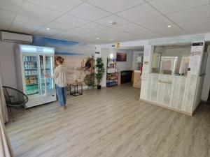 a woman standing in a room with a painting on the wall at Hostal Sol de Mallorca in El Arenal