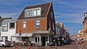 a building on the corner of a city street at Room at the Beach Egmond in Egmond aan Zee