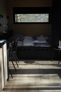 a bedroom with a bed and two chairs and a window at Tiny House für Naturliebhaber & Entdecker in Brand