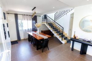 a dining room with a table and a staircase at Duplex MNE in Douala