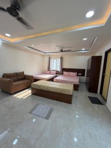 a room with three beds and a couch in it at Vilasa stays and colive in Hyderabad