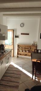 a kitchen with a table and a clock on the wall at Casa Mauri in Cusino