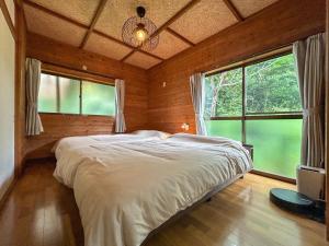 a bedroom with a bed in a room with windows at 2nd Home Kaminagayoshi in Ichihara
