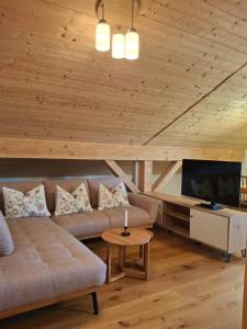 a living room with a couch and a tv at Haus Rosamirl Ferienwohnung in Wallgau