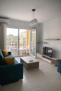a living room with a blue couch and a tv at Mare Nostrum Residence in Shëngjin
