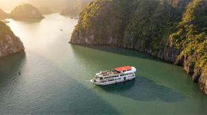 a boat in a river between two cliffs at Overnight Cruise in Hai Phong
