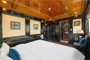 a bedroom with a white bed and blue chairs at Overnight Cruise in Hai Phong +9 photos
