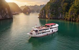 a boat in a body of water with mountains at Overnight Cruise in Hai Phong