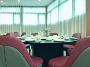 a conference room with a table and pink chairs at Hotel Kyson 凯森酒店 in Cocody