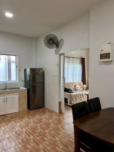 a kitchen with a stainless steel refrigerator in a room at Spacious 1br White House in Ban Nok