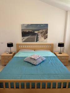a bedroom with a bed with a blue comforter and a pier at Pizzo Sabbia di Marinella in Pizzo +44 photos