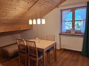 a dining room with a wooden table and chairs at Haus Rosamirl Ferienwohnung in Wallgau +10 photos
