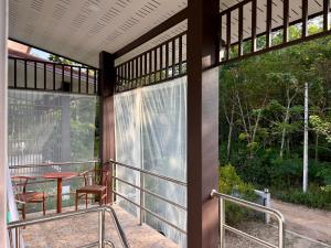 a screened in porch with two chairs and a table at Spacious 1br White House in Ban Nok