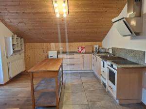 a large kitchen with wooden ceilings and a wooden table at Haus Rosamirl Ferienwohnung in Wallgau
