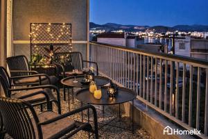 a patio with tables and chairs on a balcony at Zoi Suite - fully renovated luxury apartment in Chalkida