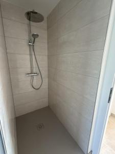 a shower with a shower head in a bathroom at La Bergerie 2 in Neufchâteau +6 photos