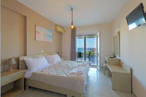 a bedroom with a bed and a view of the ocean at Sueño beach hotel in Polychrono +49 photos
