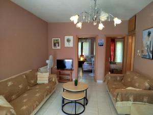 a living room with a couch and a table at Sunshine in Olympiada