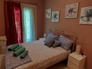 a bedroom with a bed with green pillows on it at Sunshine in Olympiada