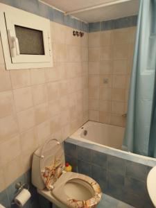 a bathroom with a toilet and a bath tub at Sunshine in Olympiada +27 photos