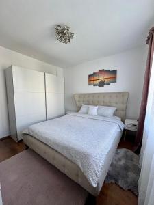 a bedroom with a bed and a chandelier at Your cozy place in Târgu-Mureş