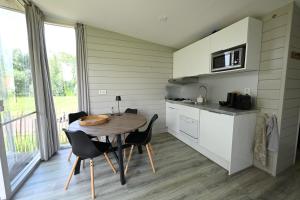 a kitchen with a wooden table and chairs in a room at Chalet Zijdewind in Zijdewind
