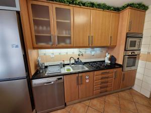 a kitchen with wooden cabinets and a sink at Caparica City & Beach in Caparica