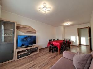 a living room with a dining room table and a television at Caparica City & Beach in Caparica