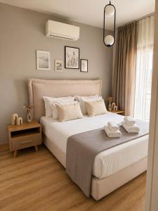 a bedroom with a white bed and a window at NŌSSA Boutique Apartment in Naousa