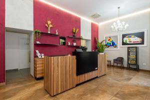 a lobby with a red wall and a reception desk at Hotel Bruman Salerno in Salerno