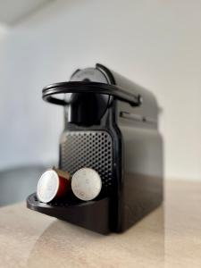 a black coffee maker with two cups on a table at Your cozy place in Târgu-Mureş