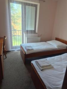 two beds in a room with a window at Hotel Na Jižní in Přerov +20 photos