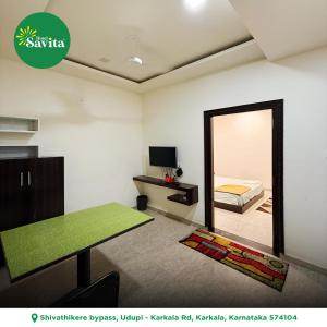 a room with a mirror and a bed and a table at Hotel savita in Kārkāl