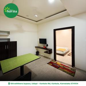 a room with a mirror and a bed and a table at Hotel savita in Kārkāl