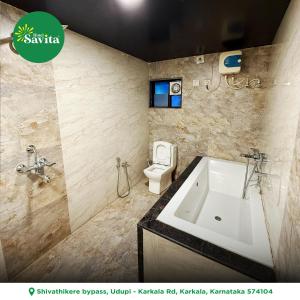 a bathroom with a sink and a toilet at Hotel savita in Kārkāl