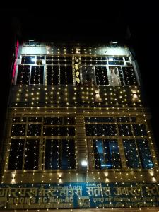 a tall building with lights on it at night at Morpankh guest house in Rīngas