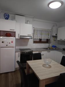 a kitchen with white appliances and a table with chairs at O Fernando in Caminha