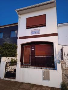 a white building with a gate and a door at O Fernando in Caminha