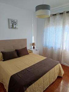 a bedroom with a large bed and a window at O Fernando in Caminha
