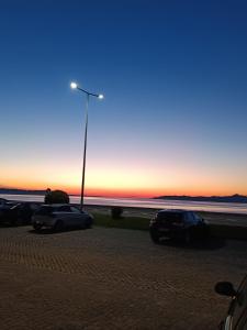 a group of cars parked in a parking lot at sunset at O Fernando in Caminha