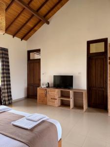 a bedroom with a flat screen tv and a bed at Aayu Lagoon in Negombo